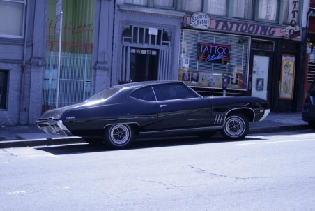 A typical San Francisco scene - Chevy Impala parked outside a tattoo parlour